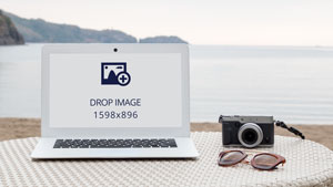 White Windows laptop mockup beside a camera and sunglasses or shades on a beach background -